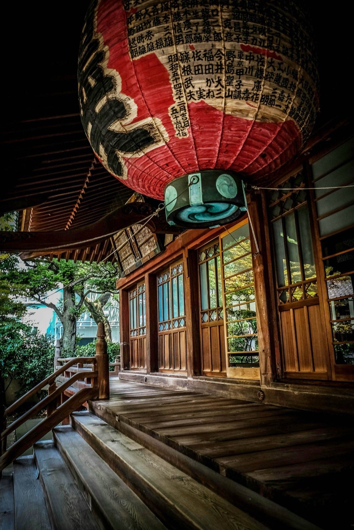 Red Green And Black Floating Lantern With Kanji Text Decoration Above Stairs